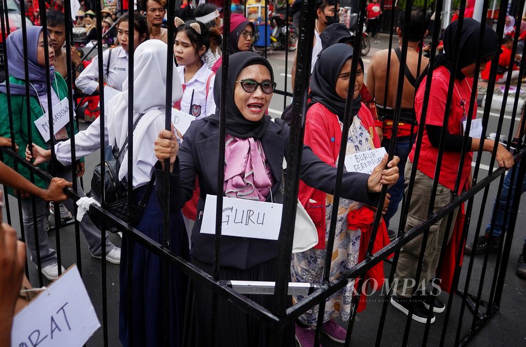 Simbol perempuan terpenjara ditampilkan para perempuan pekerja Kongres Aliansi Serikat Buruh Indonesia (KASBI) dan Aliansi Jurnalis Independen (AJI) Jakarta. Bersama sejumlah elemen masyarakat lain, mereka menggelar aksi peringatan Hari Perempuan Internasional di kawasan Patung Arjuna Wijaya, Jakarta, Jumat (8/3/2024). Mereka menyuarakan tuntutan hak-hak perempuan pekerja yang sering tereksploitasi oleh perusahaan. 