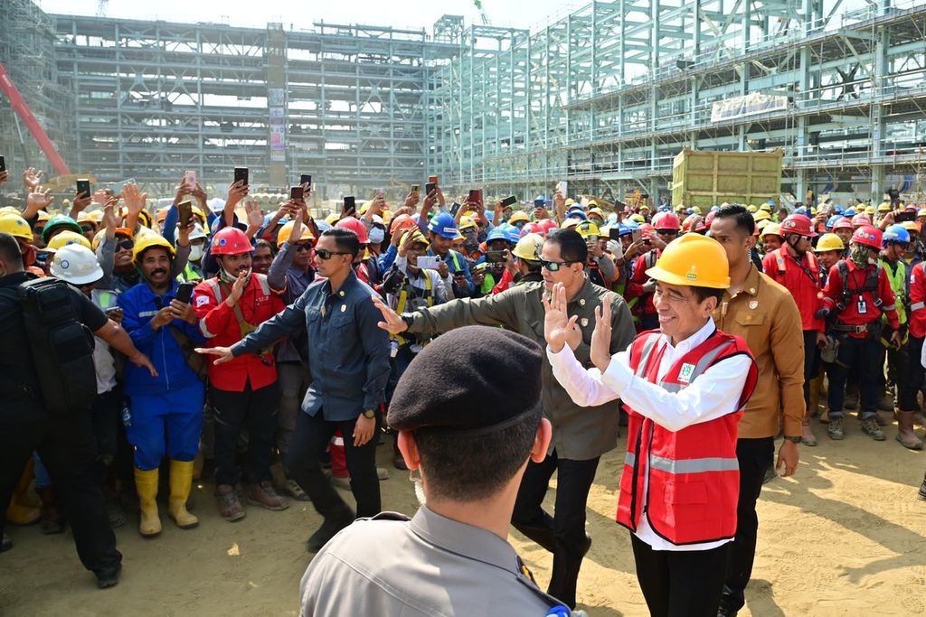 Presiden Joko Widodo menyapa para pekerja di sela peninjauan area pembangunan PT Lotte Chemical Indonesia di Kota Cilegon, Provinsi Banten, Selasa (12/9/2023).