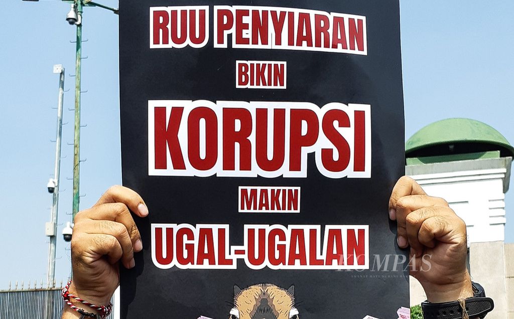 Journalists unfurl posters during a demonstration against the Broadcasting Bill in front of the DPR Building, Jakarta, Monday (27/5/2024). 