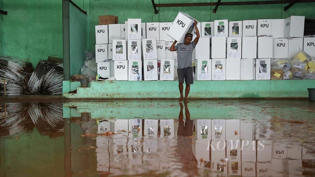 Pekerja memindahkan logistik pemilu yang masih terselamatkan dari genangan air dan lumpur di gudang penyimpanan logistik pemilu di GOR PGRI, Kecamatan Ciseeng, Kabupaten Bogor, Senin (15/4/2019). 