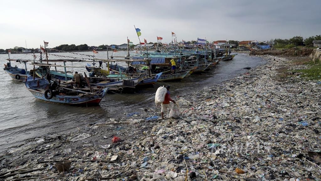 Pemulung melintasi timbunan sampah yang didominasi sampah plastik di pesisir Desa Dadap, Kecamatan Juntinuyat, Kabupaten Indramayu, Jawa Barat, Sabtu (1/12/2018). 