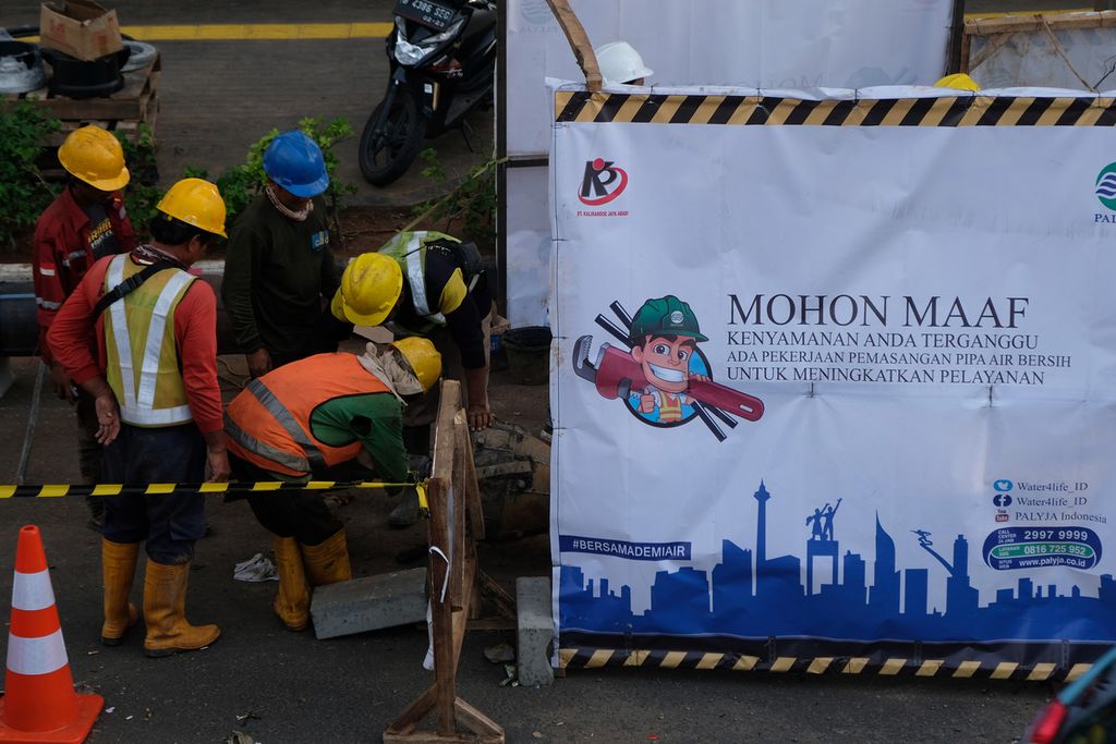 Pekerja menyelesaikan pekerjaan pemasangan pipa air bersih di Jalan Gatot Subroto, Jakarta Pusat, Senin (21/11/2022).