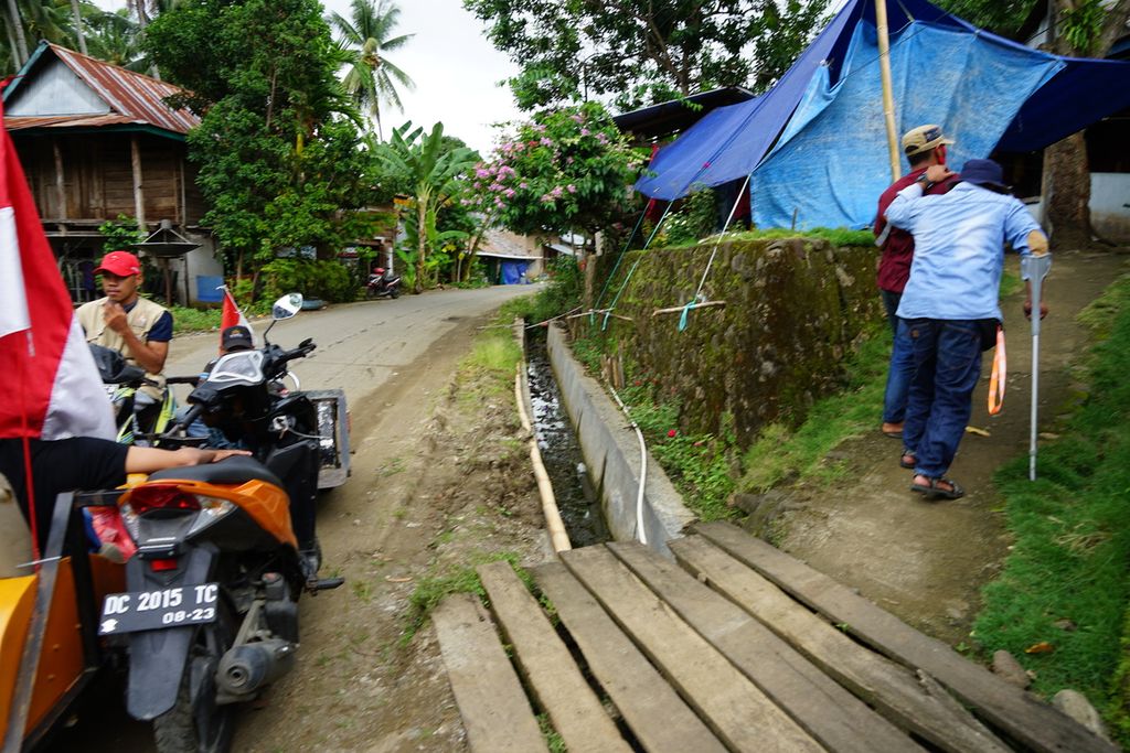 Sukarelawan dari TIm Relawan Kemanusiaan yang sebagian besar adalah difabel menyusuri permukiman untuk mencari penyintas gempa yang difabel, juga warga lansia, di Mamuju, Sulawesi Barat, akhir Januari 2021.