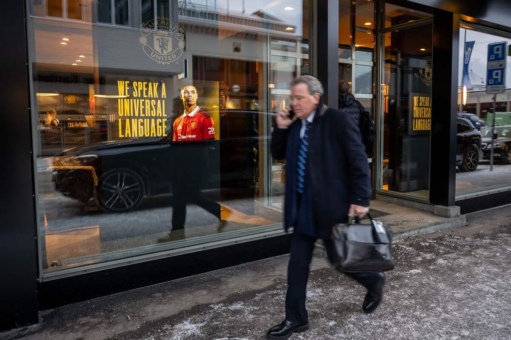 Seorang pebisnis berjalan melewati <i>lounge </i>Manchester United di kawasan resot Alpine, Davos, Swiss, saat berlangsung pertemuan tahunan Forum Ekonomi Dunia (World Economic Forum/WEF), 19 Januari 2023. 