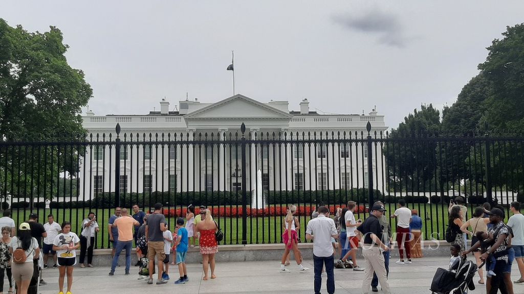 Pengunjung berfoto di depan Gedung Putih, Washington DC, Amerika Serikat, 18 Juli 2022.