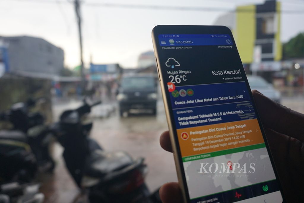 Seorang warga memantau kondisi cuaca di Kota Kendari, Sulawesi Tenggara, Kamis (19/12/2019).