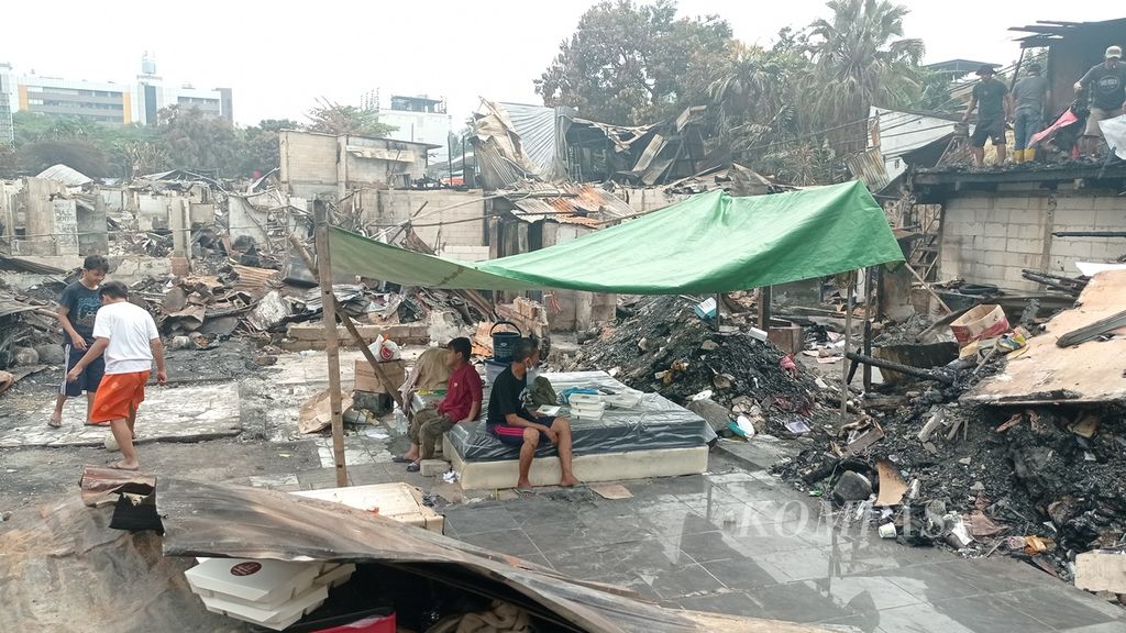 Warga membersihkan puing kebakaran supaya bisa jadi tempat mengungsi di RT 008 RW 008 Jalan Simprug Golf II, Kelurahan Grogol Selatan, Kecamatan Kebayoran Lama, Jakarta Selatan, Rabu (24/8/2022).