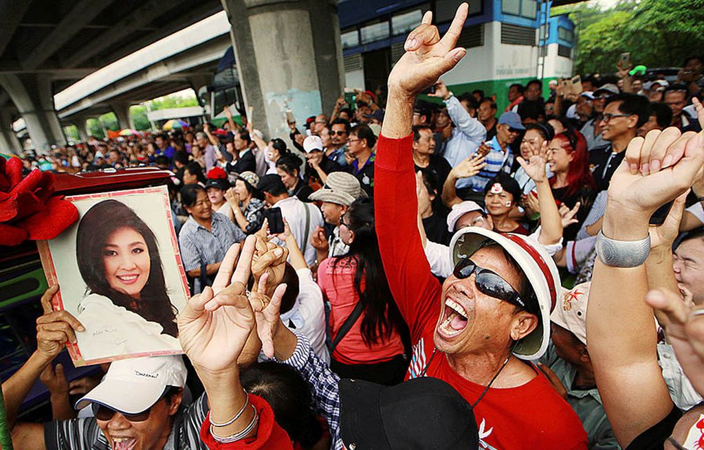 Para pendukung mantan Perdana Menteri Thailand, Yingluck Shinawatra, bersorak-sorak di luar gedung Mahkamah Agung pada pembacaan vonis dalam penyelewengan program dana subsidi beras yang tak dihadiri Yingluck di Bangkok, Thailand, Jumat (25/8). Yingluck dikabarkan telah meninggalkan Thailand.