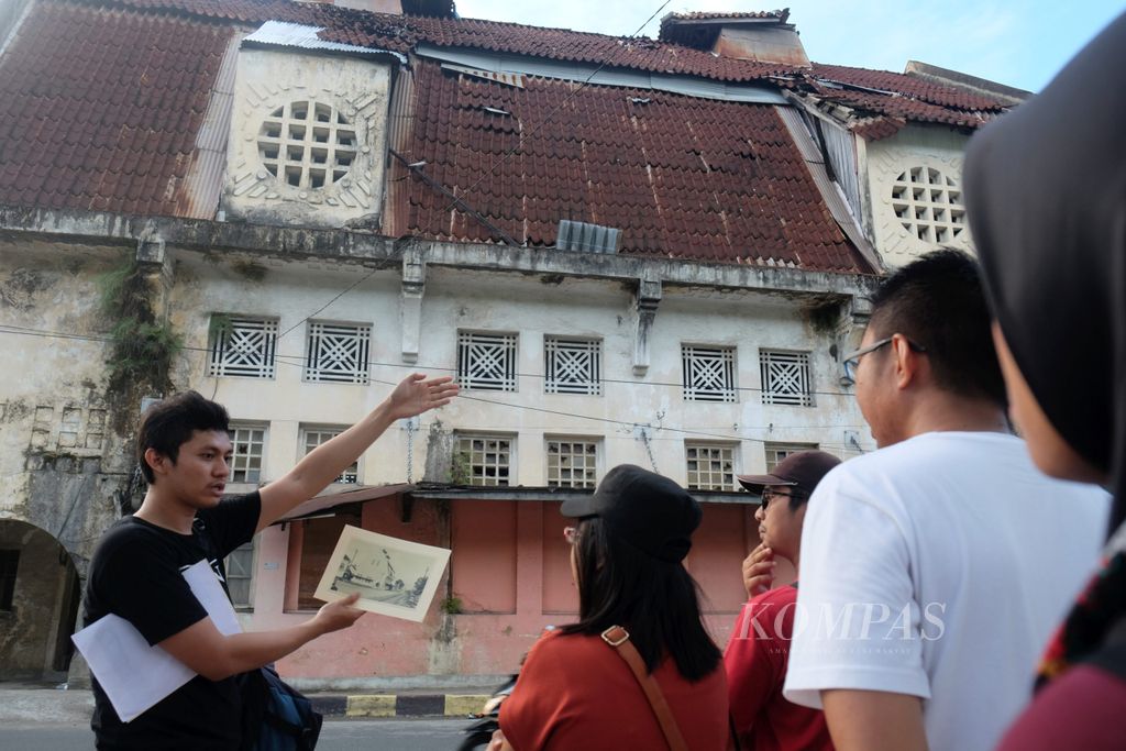 Peserta menyimak penjelasan Koordinator Padang Heritage Bayu Hariyanto (paling kiri) tentang gedung Geo Wehry and Co yang merupakan salah satu bangunan cagar budaya di kawasan Kota Tua Padang, Kota Padang, Sumatera Barat, Minggu (16/7/2017) lalu. Kunjungan ke bangunan tersebut merupakan salah satu kegiatan dalam Padang Walk Heritage atau menyusuri bangunan cagar budaya di kawasan Kota Tua Padang. Kegiatan itu diselenggarakan secara sukarela untuk menggairahkan kembali kecintaan anak muda terhadap Kota Tua Padang.
