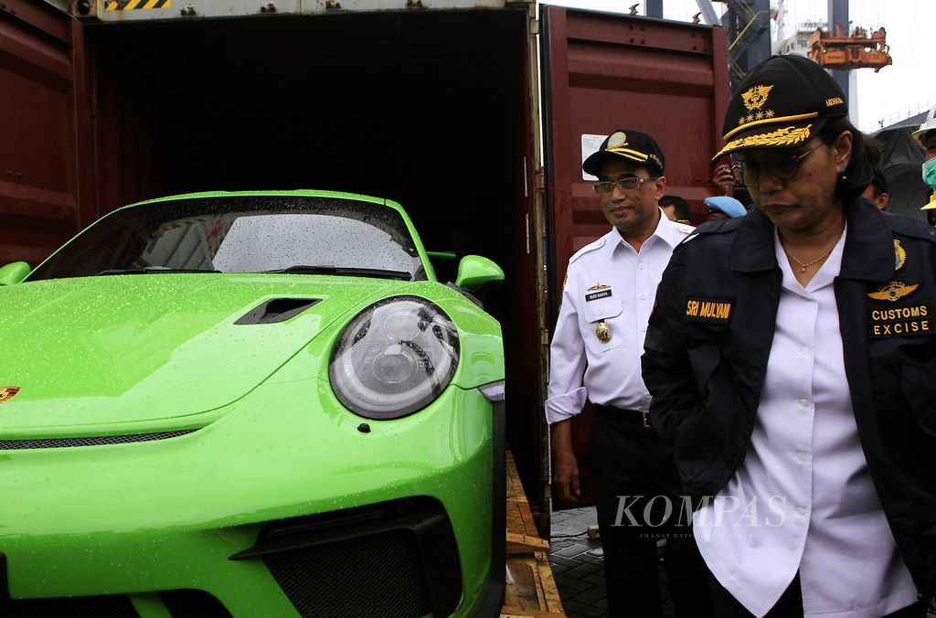 Menteri Keuangan Sri Mulyani (depan) dan Menteri Perhubungan Budi Karya Sumadi (kiri, belakang) meninjau barang bukti penyelundupan kendaraan mewah di halaman parkir Terminal Peti Kemas Koja, Jakarta, Desember 2019. 