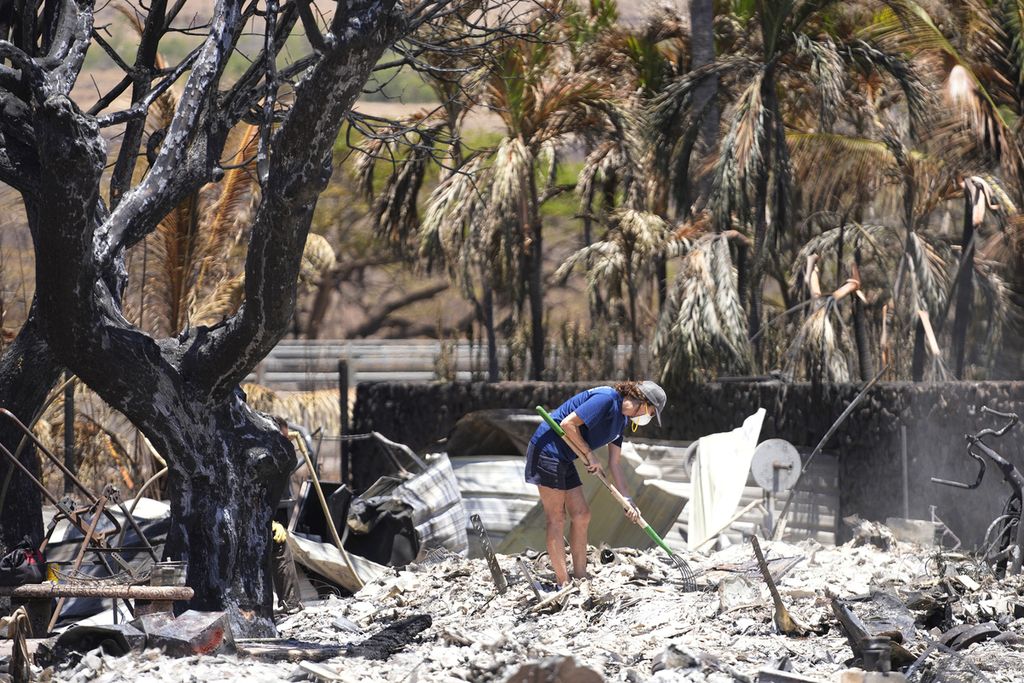 A resident dismantles the debris of a burnt house in Lahaina, Hawaii, on Friday (11/8/2023).