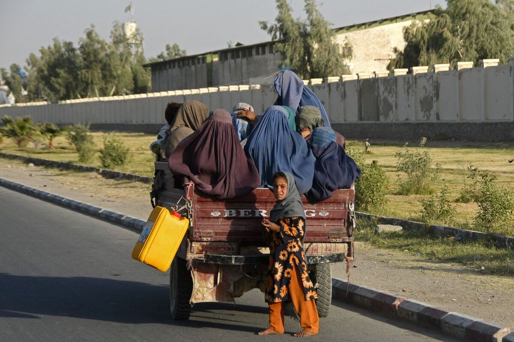 Perempuan-perempuan Afghanistan dengan mengenakan burkak naik di atas kendaraan bak terbuka di Kandahar, Afghanistan, Minggu (25/12/2022). 