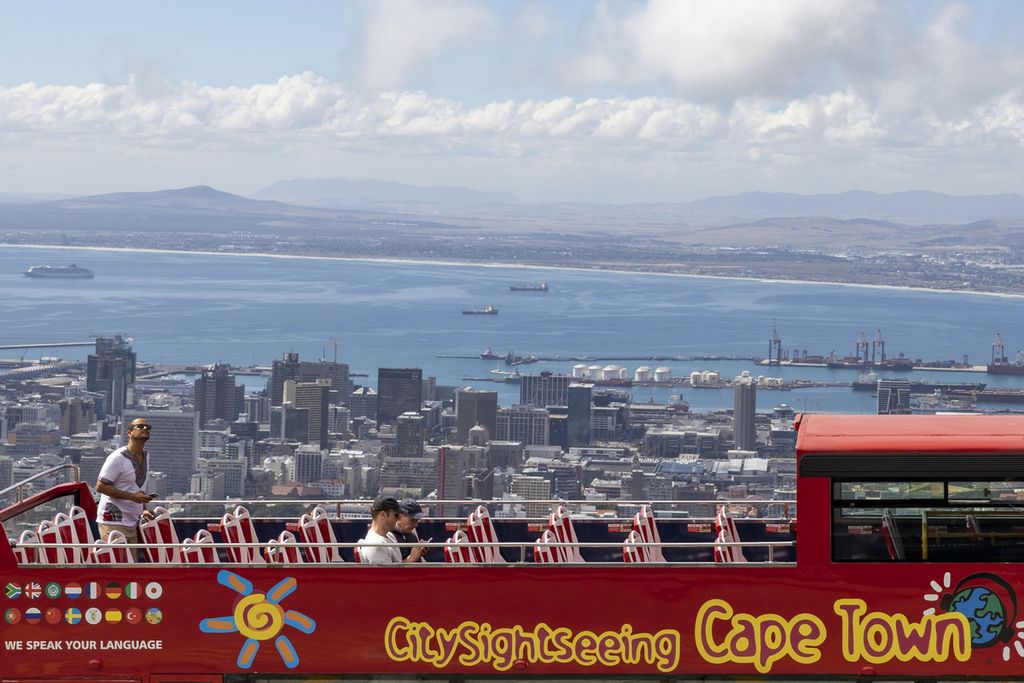 Sebuah bus tingkat beratap terbuka berhenti di area Table Mountain dengan pemandangan mengarah ke kota Cape Town, Afrika Selatan, 20 Maret 2020. 