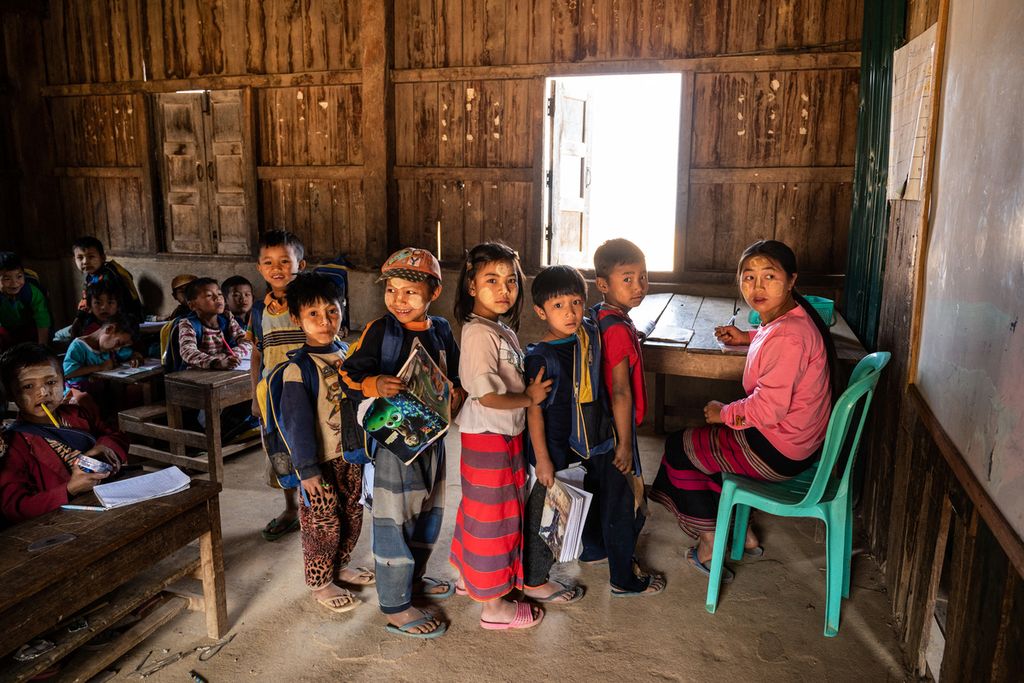 Dalam foto yang diambil pada 9 Maret 2023 ini tampak anak-anak dari beberapa desa hadir di sebuah kelas di Desa Kone Tar, Namhsan yang berada di wilayah utara Negara Bagian Shan, Myanmar. Sekolah mereka sedang dibangun kembali setelah bentrokan dengan tentara Myanmar. 