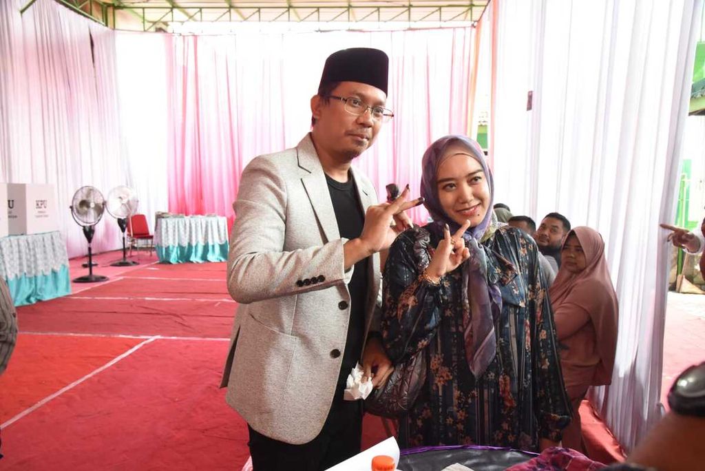 Bupati Sidoarjo Ahmad Muhdlor Ali dan istrinya, Sa'adah, saat menggunakan hak pilihnya di TPS 09 Desa Kenongo, Kecamatan Tulangan, Rabu (14/2/2024).