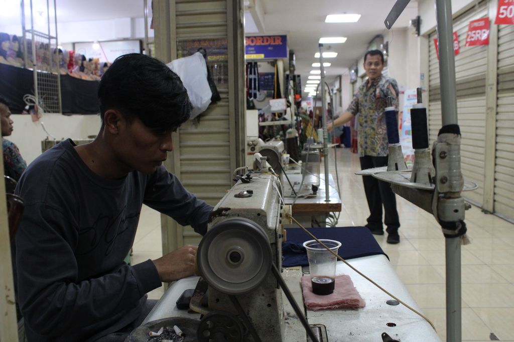Seorang penjahit pakaian bekerja di kiosnya yang berada di pusat perbelanjaan Balubur Town Square, Kota Bandung, Jawa Barat, Jumat (22/9/2023).
