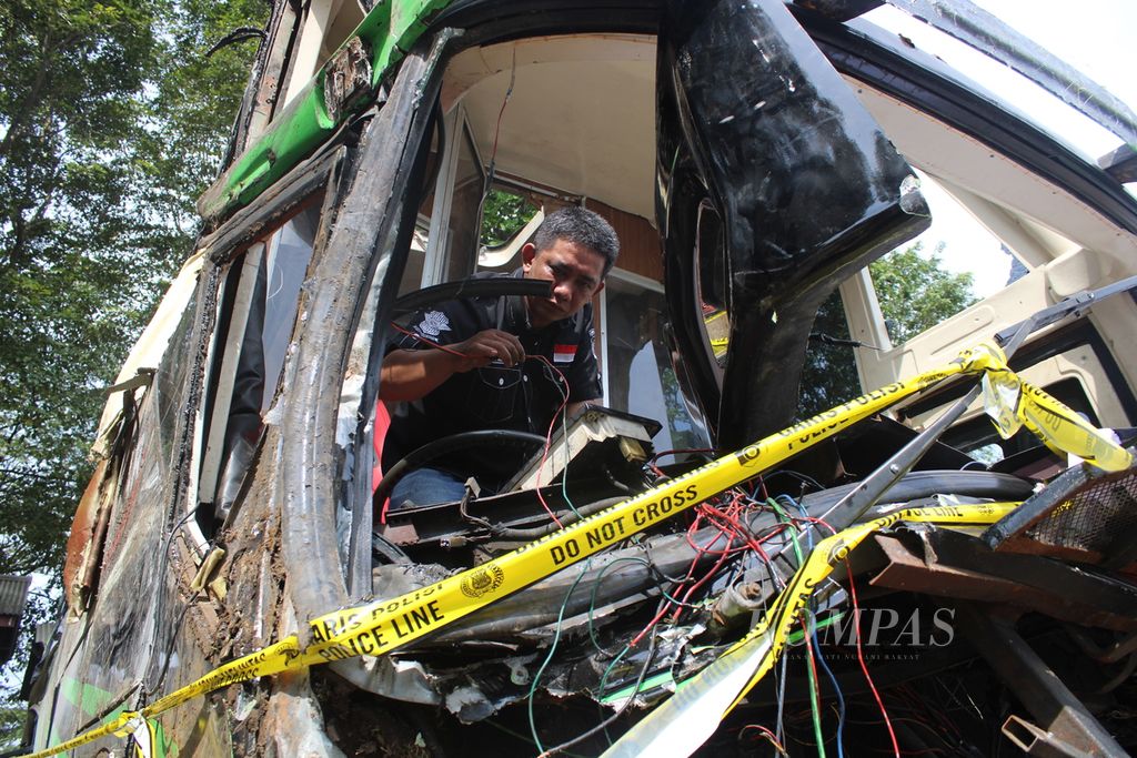 Petugas mengamati kabel dalam bus yang kecelakaan di Terminal Subang, Jawa Barat, Minggu (12/5/2024). 
