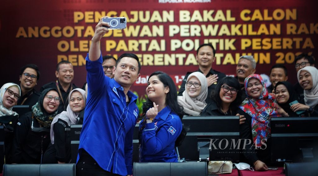 Ketua Umum Partai Demokrat Agus Harimurti Yudhoyono (kiri) beserta istrinya, Annisa Pohan, berswafoto dengan pegawai KPU setelah menyerahkan berkas bakal calon anggota DPR dari partainya kepada Ketua KPU Hasyim Asyari di Kantor Komisi Pemilihan Umum (KPU), Jakarta, Minggu (14/5/2023). 