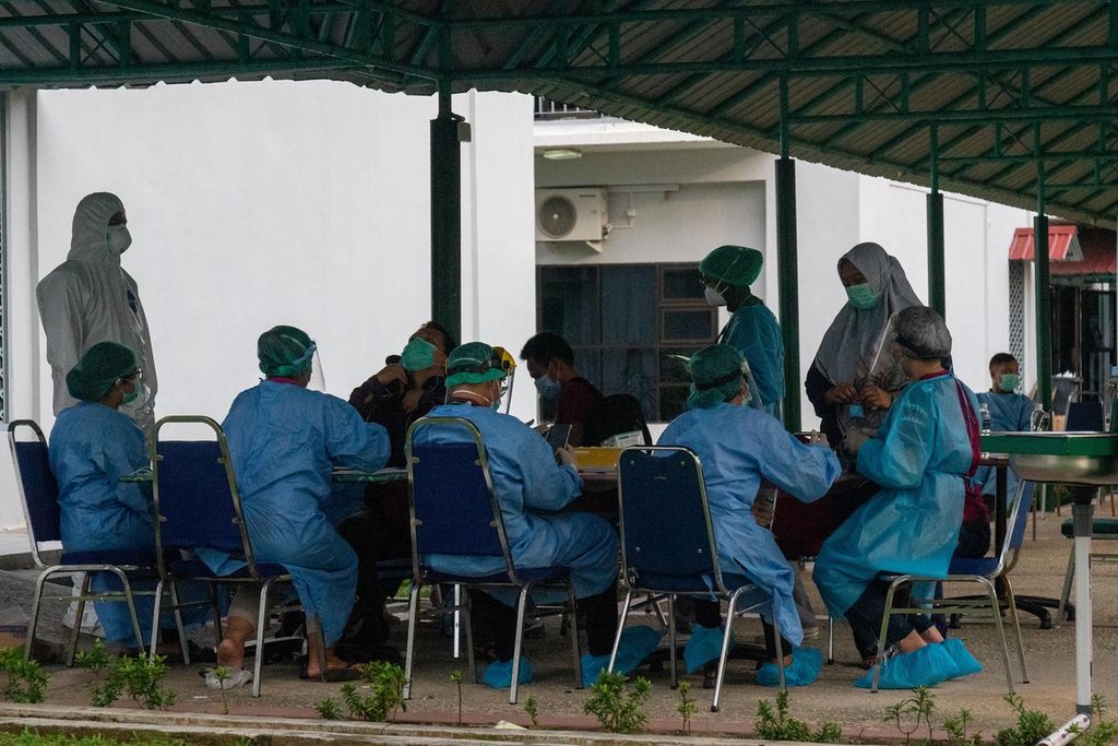 Petugas kesehatan memeriksa sejumlah pasien Covid-19 yang baru tiba di lokasi karantina terpadu Asrama Haji Kota Batam, Kepulauan Riau, Jumat (11/6/2021).