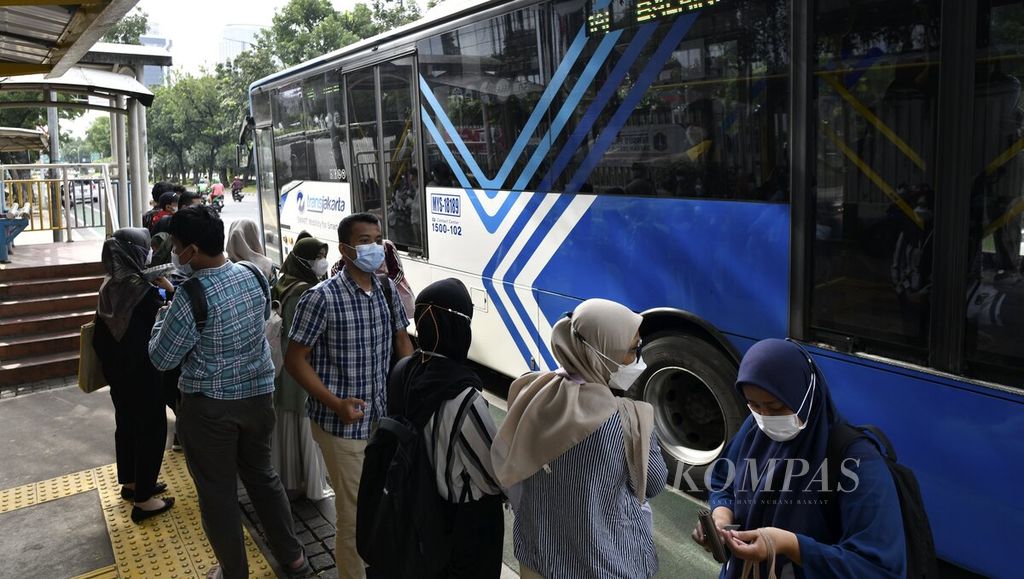 Warga antre naik bus Transjakarta di Jalan Medan Merdeka Selatan, Jakarta Pusat, Sabtu (8/1/2022). Warga cenderung tetap beraktivitas di luar rumah meski saat ini dibayangi lonjakan kasus baru Covid-19, terutama karena varian Omicron. 