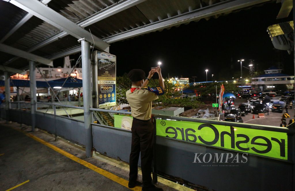 Pramuka mendokumentasikan atrean kendaraan pemudik sebagai laporan berkala di pelabuhan penyeberangan Merak, Cilegon, Banten, Kamis (28/4/2022) malam.