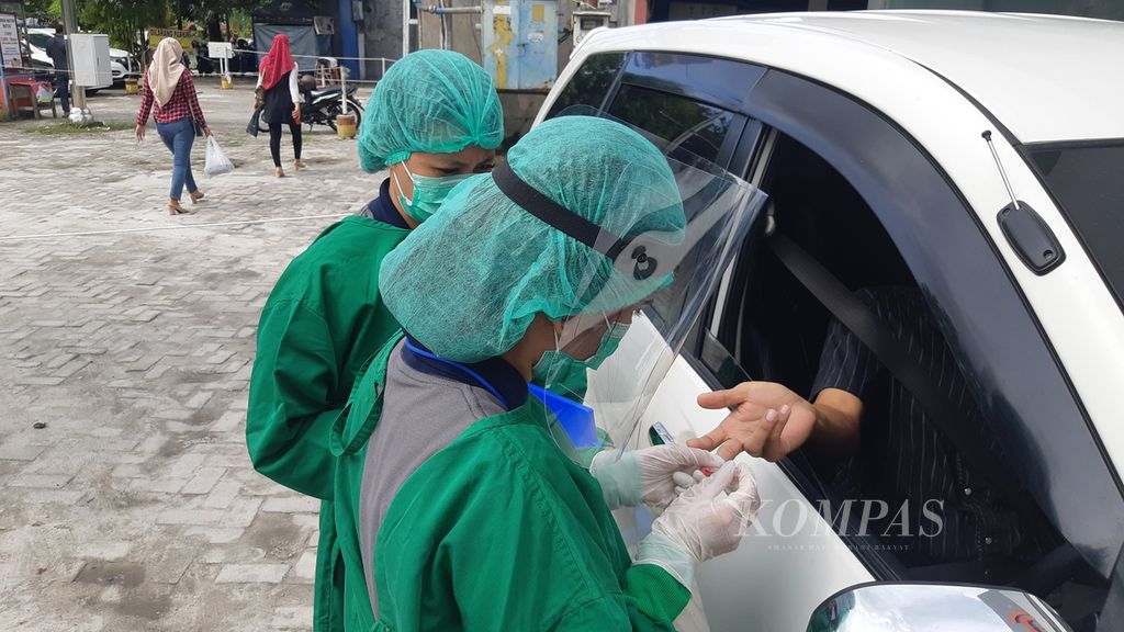 Petugas kesehatan RS Siloam Palangkaraya mengambil sampel darah dalam <i>drive thru rapid test</i> di pusat belanja Kota Palangkaraya, Kalimantan Tengah, Sabtu (9/5/2020).