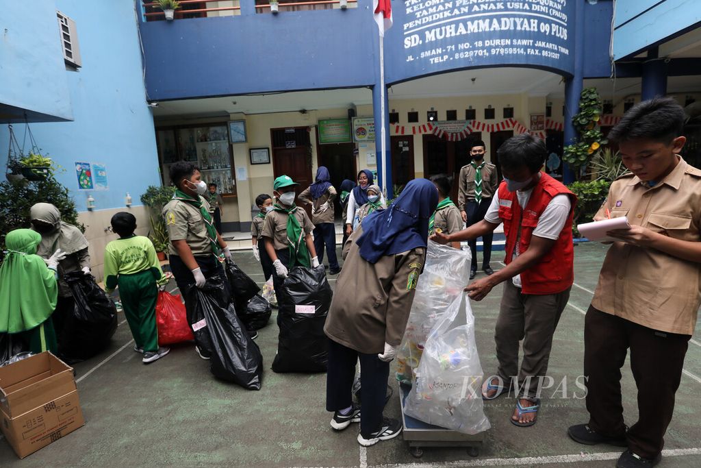 Petugas Bank Sampah Gunung Emas Pulo Kambing menimbang karung sampah yang telah dipilah dan dikumpulkan siswa SD Muhammadiyah 09 Plus, Duren Sawit, Jakarta, Rabu (19/10/2022). 