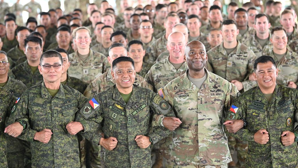 Tentara Filipina dan AS dipimpin Panglima Militer Filipina Letnan Jenderal Romeo Brawner (depan, ketiga dari kiri) dan Letnan Jenderal Xavier Brunson (depan, kedua dari kanan) bergandengan tangan pada upacara pembukaan latihan militer AS dan Filipina di Fort Magsaysay, Provinsi Nueva Ecija, 13 Maret 2023.