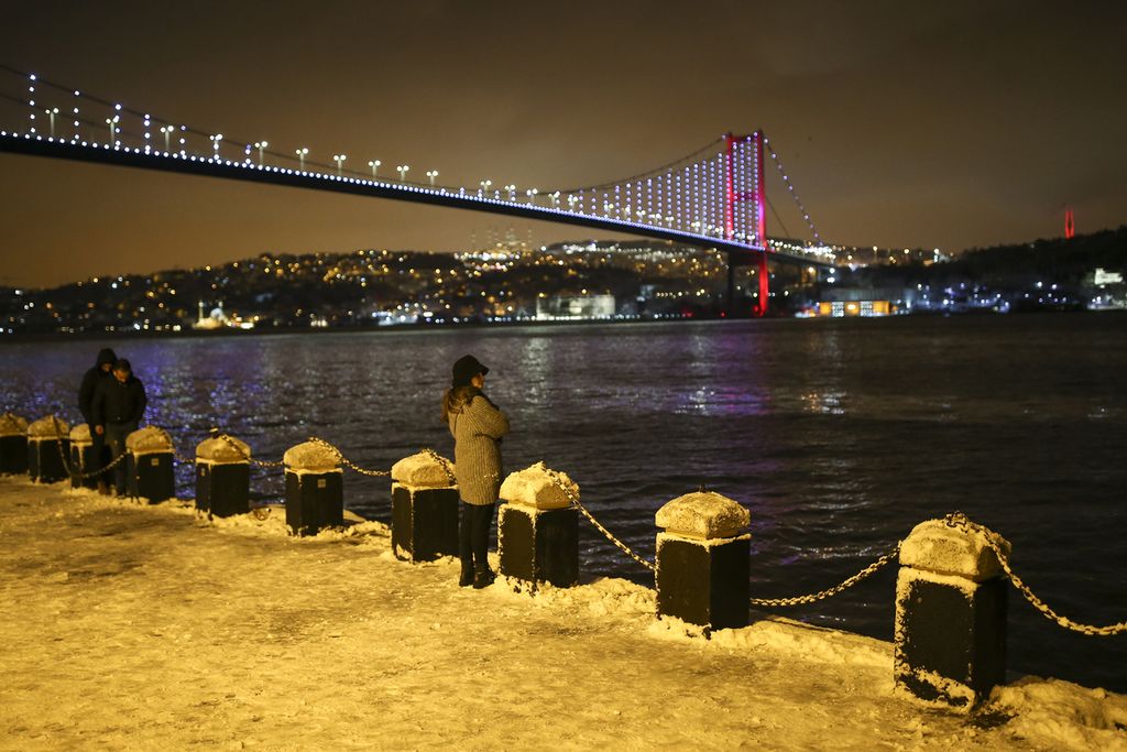 Warga Turki tengah menikmati keindahan Selat Bosporus di Istanbul Turki di tengah cuaca yang bersalju pada Minggu (23/1/2022).