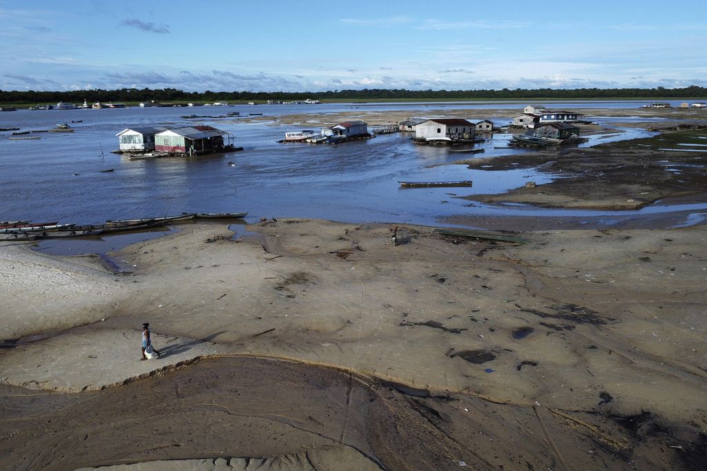 Seorang wanita berjalan di daerah yang terkena dampak kekeringan di dekat Sungai SolimÃµes, di Tefe, Negara Bagian Amazonas, Brasil, Rabu, 19 Oktober 2022. Berbulan-bulan setelah mengalami banjir yang menghancurkan tanaman, ribuan keluarga di Amazon, Brasil, kini menghadapi bencana yang parah, kekeringan. 
