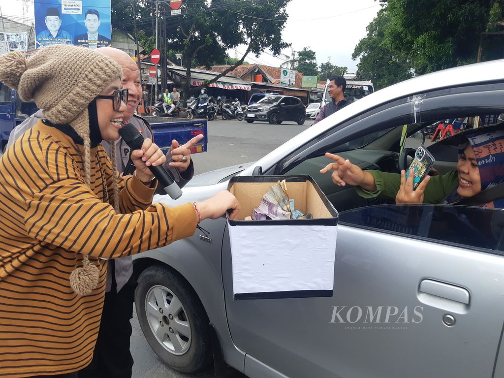 Warga menyumbang dalam aksi penggalangan dana untuk korban gempa Cianjur, di depan Markas Polresta Cirebon, Jawa Barat, Rabu (23/11/2022). Kegiatan itu menghadirkan Diana Sastra (memegang dus), artis gitar suling (tarling) dangdut.