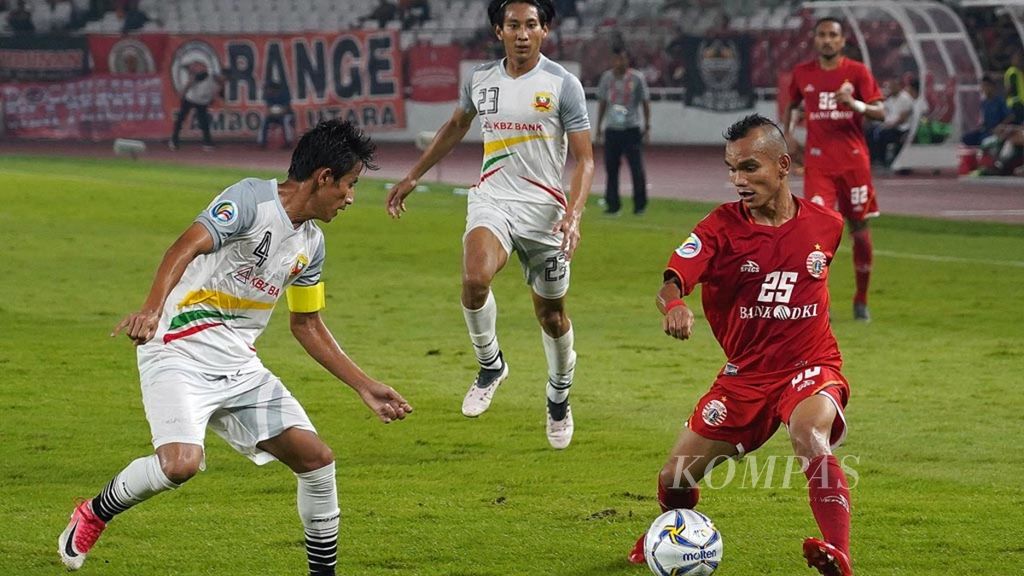 Striker Persija Jakarta, Riko Simanjuntak (kanan), menerobos penjagaan dua pemain Shan United Myanmar, David Htan (kiri) dan Hein Pyo Win (tengah), dalam laga Piala AFC 2019 di Stadion Gelora Bung Karno, Jakarta, Rabu (15/5/2019).