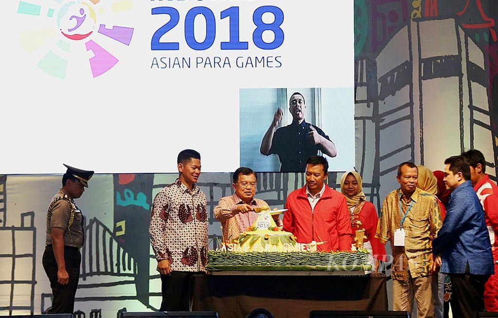 Wakil Presiden Jusuf Kalla (ketiga dari kiri), didampingi Menteri Pemuda dan Olahraga Imam Nahrawi, Ketua Inasgoc Erick Thohir, serta Ketua Inapgoc Raja Sapta Oktohari, memotong tumpeng pada acara hitung mundur pelaksanaan Asian Para Games 2018 di JIExpo Kemayoran, Jakarta Pusat, Jumat (6/10). Pada kesempatan tersebut juga diberikan secara simbolis bonus bagi para atlet yang meraih medali di SEA Games dan ASEAN Para Games Kuala Lumpur 2017.