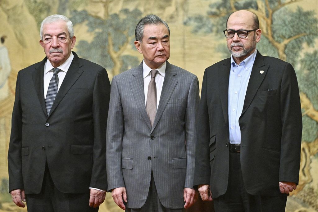 Menteri Luar Negeri China Wang Yi (tengah) berpose bersama Mahmoud al-Aloul, Wakil Ketua Fatah (kiri), dan Mousa Abu Marzouk, pejabat senior Hamas, di Wisma Tamu Negara Diaoyutai di Beijing, China, Selasa (23/7/2024).