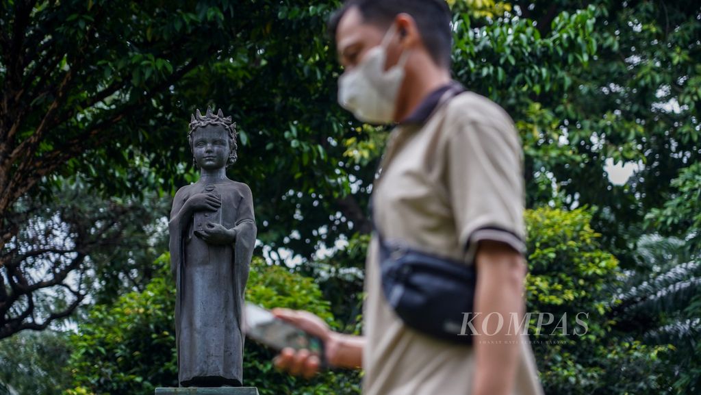 Warga melintasi patung Anna de Kiev yang menjadi simbol persahabatan <i>sister city</i> Jakarta-Kiev, Ukraina. Patung ini terpasang di Taman Cattleya, Kemanggisan, Jakarta Barat, Rabu (9/3/2022). 