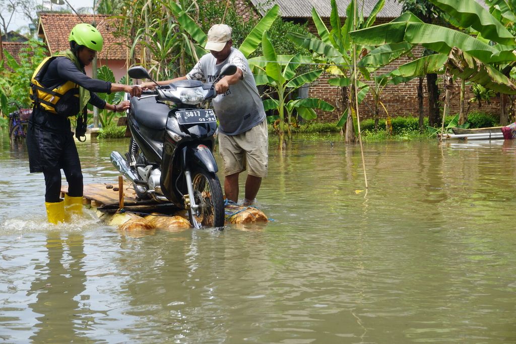 Banjir merendam Desa Nusadadi, Kecamatan Sumpiuh, Banyumas, Jawa Tengah, Jumat (18/3/2022). Sekitar 20 warga mengungsi ke tempat aman. Tampak warga mengevakuasi motornya. 