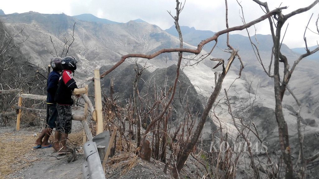 Dua wisatawan domestik melihat kondisi kawasan di sekitar kawah Gunung Kelud di Desa Sugihwaras, Ngancar, Kediri, Jawa Timur, yang berjarak sekitar 3 kilometer dari kawah, 11 Maret 2014.