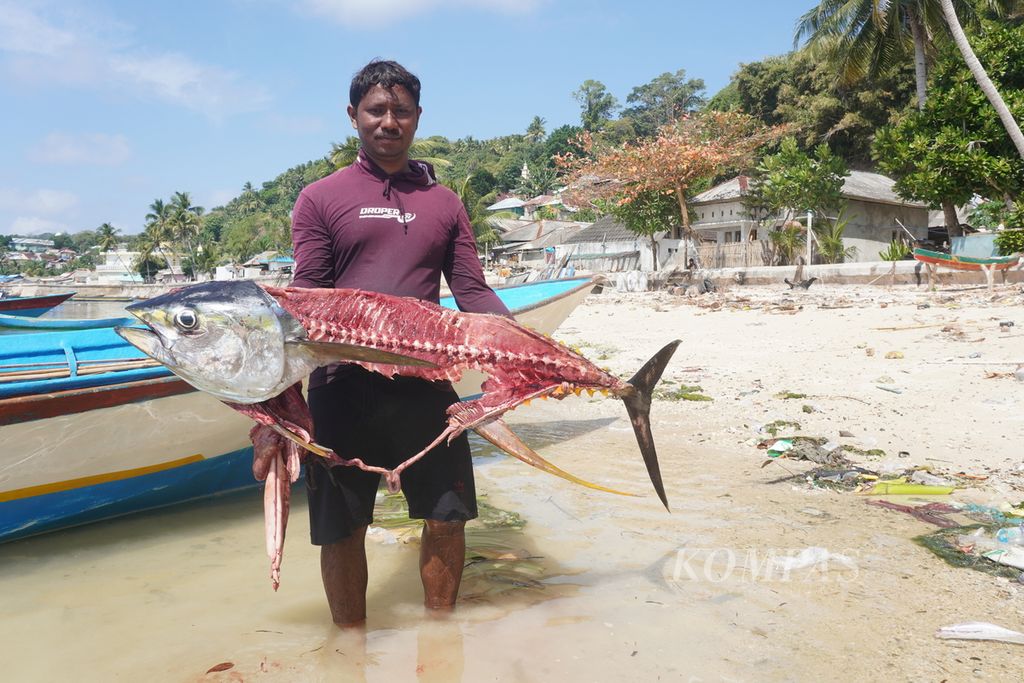 Ruli (31), nelayan pemburu tuna di Pulau Run, Kecamatan Banda, Maluku Tengah, Maluku, menunjukkan tuna hasil tangkapannya, Selasa (19/9/2023). Hari itu Ruli berhasil membawa pulang tiga ikan tuna dengan bobot 50-70 kilogram per ekor.