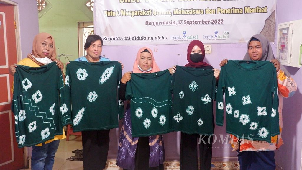 Warga memperlihatkan kaus sasirangan yang sudah jadi dalam kegiatan lokakarya pembuatan sasirangan dan <i>ecoprint </i>di Rumah Kreatif dan Pintar, Kelurahan Basirih Selatan, Banjarmasin Selatan, Kota Banjarmasin, Kalimantan Selatan, Sabtu (17/9/2022).