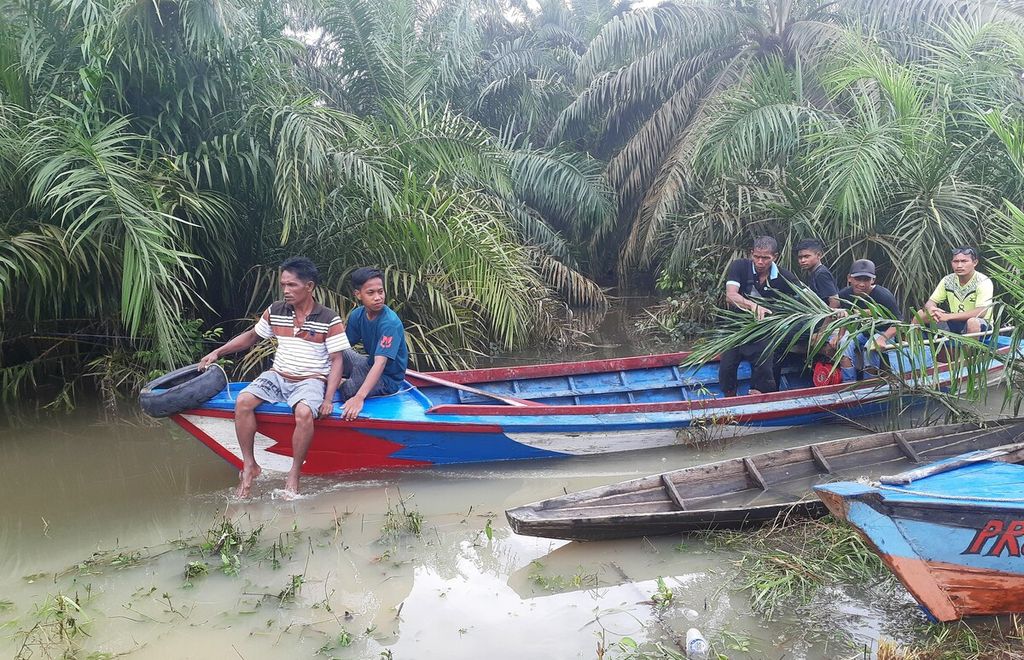 Sebagian warga naik perahu akibat banjir yang melanda Desa Nyogan, Mestong, Muaro Jambi, Rabu (9/11/2022). Banjir itu disebabkan meluapnya sejumlah sungai yang ada di sana.