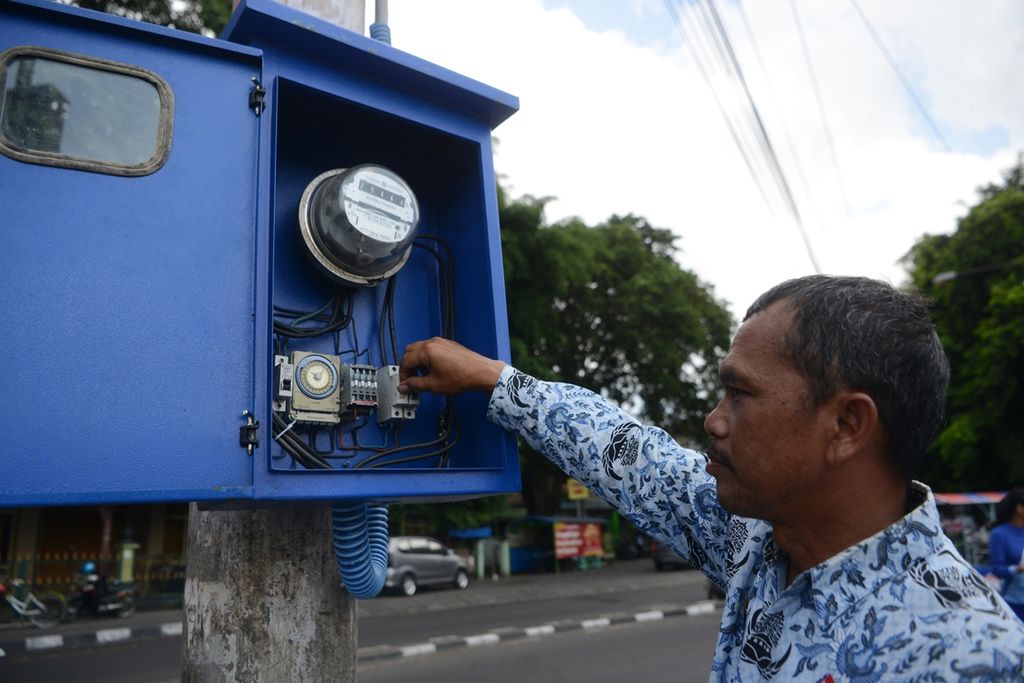 Petugas mengeset peranti pengatur waktu nyala lampu penerangan jalan umum di Alun-alun Utara, Yogyakarta, Senin (11/11/2019). Pengesetan dilakukan berkala dengan menyesuaikan waktu terbit matahari. Hal itu dilakukan sebagai salah satu upaya penghematan energi.