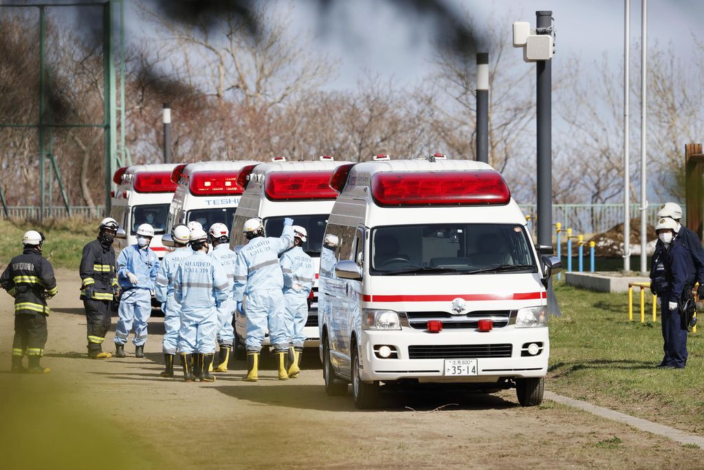 Sejumlah mobil ambulans disiagakan di sebuah kompleks sekolah di Shari, utara Hokkaido, Minggu (24/4/2022). H 