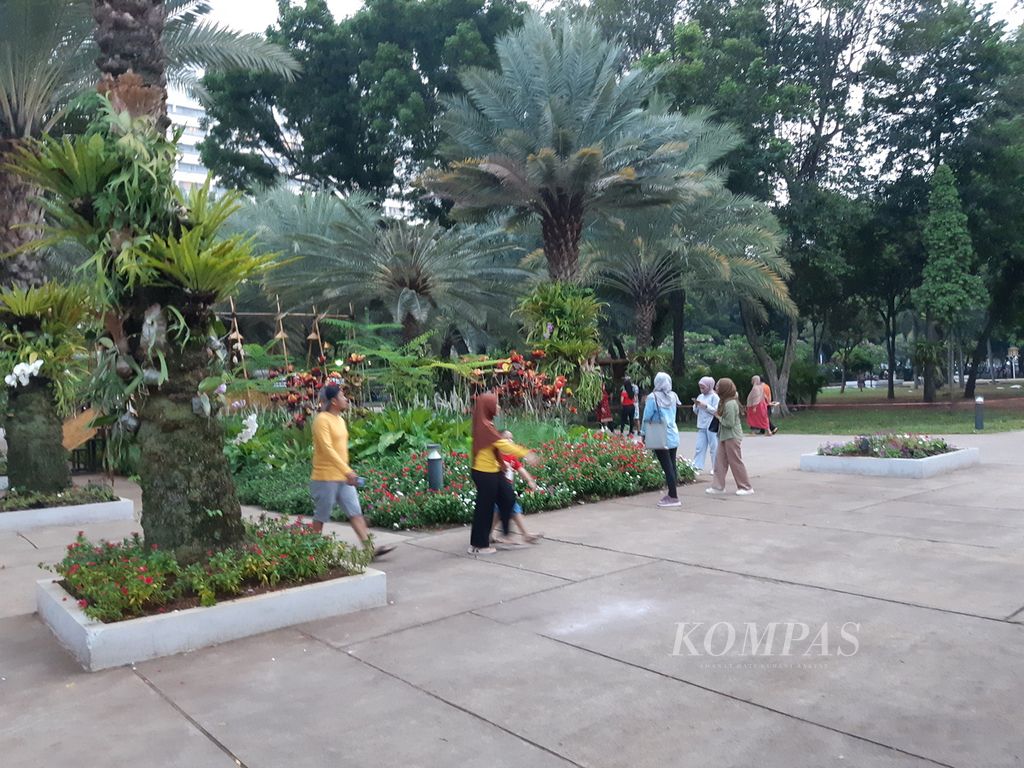 Sejumlah warga sedang menghabiskan liburan di Taman Lapangan Banteng, Jakarta Pusat, Minggu (12/11/2023). Taman ini menjadi pilihan warga karena dinilai sangat cantik dengan beragam bunga warna-warni dan lebatnya tanaman peneduh setelah direvitalisasi pada 2017.