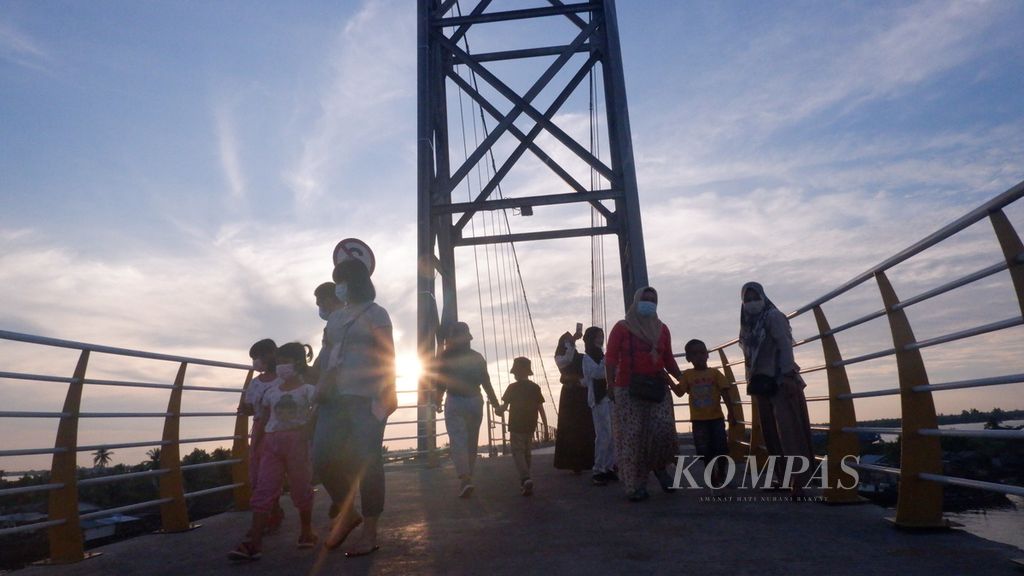 Warga bersantai menikmati senja sambil menunggu waktu berbuka puasa di atas Jembatan Antasan Bromo di Kelurahan Mantuil, Kecamatan Banjarmasin Selatan, Kota Banjarmasin, Kalimantan Selatan, Sabtu (1/5/2021).