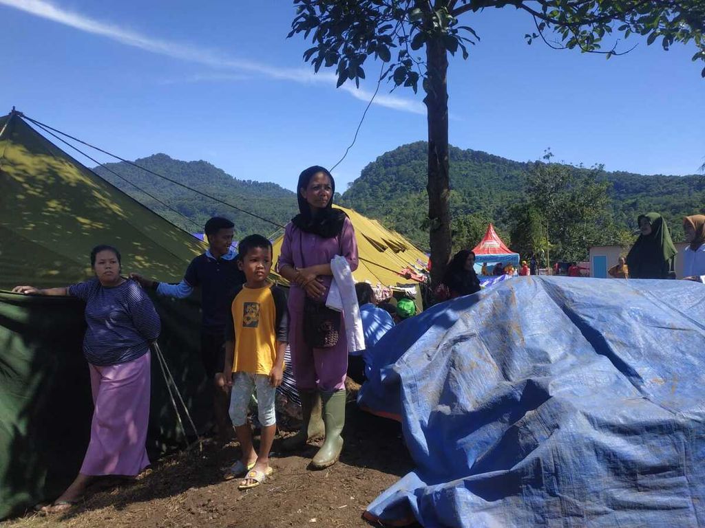 Sejumlah warga Desa Cijedil, Kecamatan Cugenang, Kabupaten Cianjur, Jawa Barat, berdiri di depan tenda pengungsian mereka, Selasa (29/11/2022).
