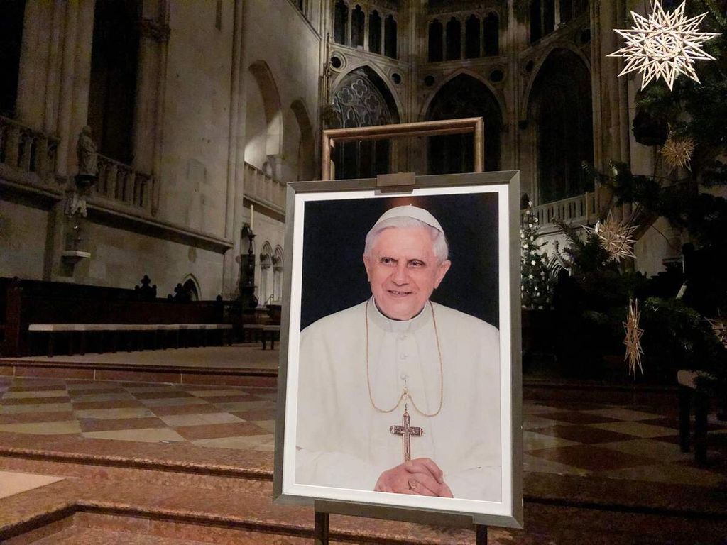 Foto Paus Emeritus Benediktus XVI dipajang di Katedral Regensburg, Jerman pada 29 Desember 2022. Pada 31 Desember 2022, Paus Emeritus meninggal dan akan dimakamkan di Vatikan pada Kamis (5/1/2023)