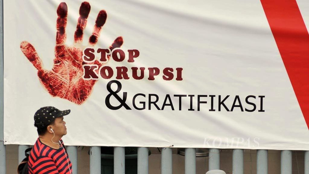 Warga melintas di depan spanduk bertuliskan "Stop Korupsi dan Gratifikasi" di Jalan MH Thamrin, Jakarta, Kamis (13/9/2018). Keberadaan spanduk tersebut diharapkan bisa membangun sikap dan kesadaran masyarakat untuk tidak korupsi dan menerima gratifikasi.