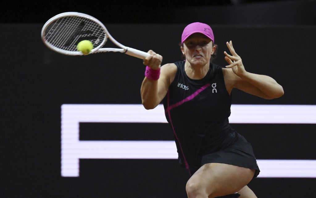 Tennis player Iga Swiatek hits the ball towards Elise Mertens during the round of 16 match of the WTA 500 Stuttgart at the Porsche Arena in Stuttgart, Germany, on Thursday (18/4/2024). Swiatek defeated Elise Mertens with a score of 6-3, 6-4.