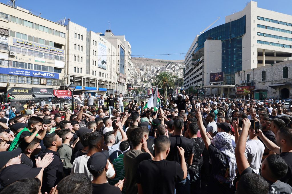 Rakyat Palestina di kota Nablus, Tepi Barat, Sabtu (7/10/2023), merayakan serangan Hamas dari Jalur Gaza ke Israel. 