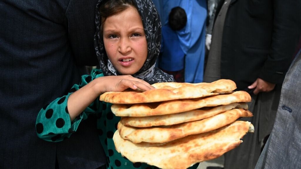 Seorang anak perempuan mendapatkan roti gratis dari pemerintah setempat untuk berbuka puasa di Kabul, Afghanistan, 29 April 2020. 